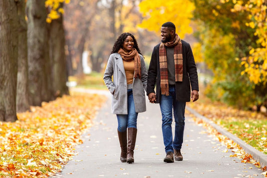 happy couple walking down a path in the fall