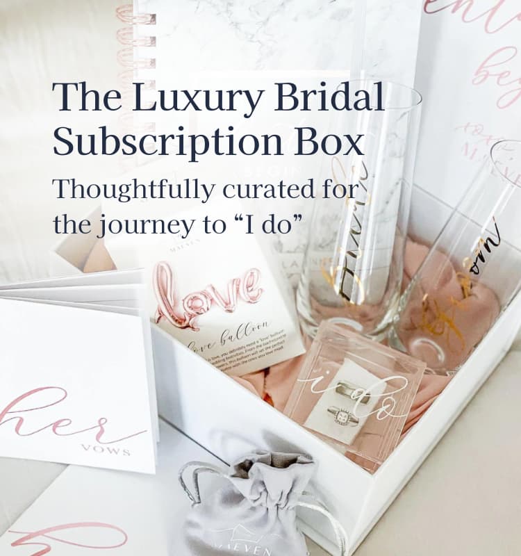 A luxury bridal subscription box with bride and groom champagne flutes, wedding planner, vow books, ring box, jewelry, love balloon